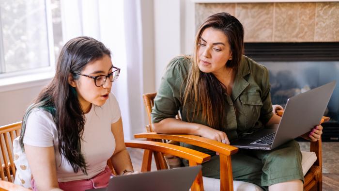 Parent and child using laptops and having a conversation