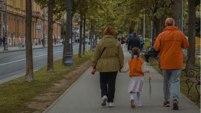 This is a photo of a family walking down a path in a park.