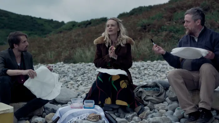 The Ballad of Wallis Island: Two White men and one White woman make lanterns on the beach