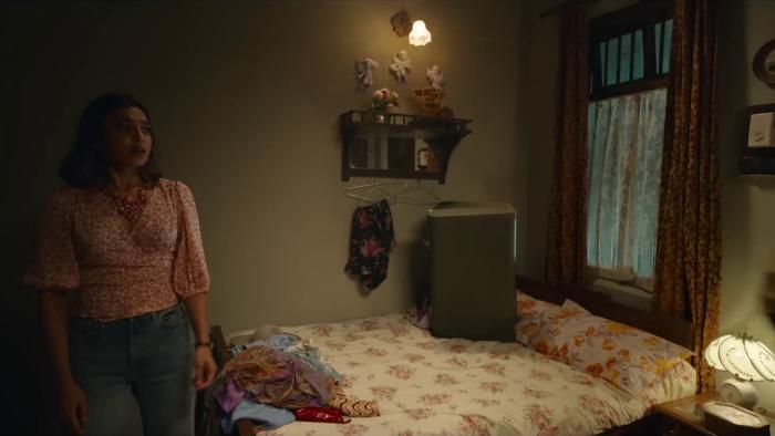 Merry Christmas: Maria stands next to a bed a dimly-lit room