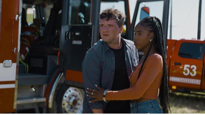 57 Seconds Movie: Josh Hutcherson and Lovie Simone embrace each other in front of a first responder vehicle