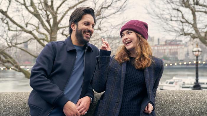 What's Love Got to do With It?: A young British-Asian man and a young White woman laugh together outside on an autumn's day
