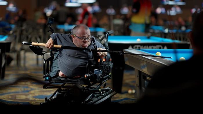 96 Pounds of Dynamite movie: Chad holds a cue stick as he shoots pool at a pool table