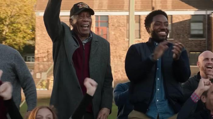 A Good Person Movie: Morgan Freeman stands and cheers in the stands next to his adult son (Chinaza Uche)
