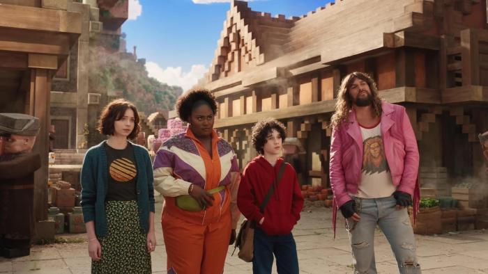 A Minecraft Movie: The human characters stand in a Minecraft town
