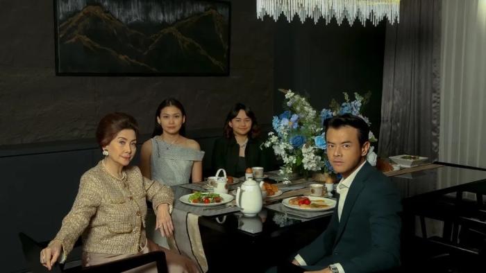 A Normal Woman: Liliana, Milla, Angel, and Jonathan pose for a picture at a luxuriously set dining table.