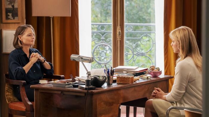 A Private Life movie: Jodie Foster clasps her hands while she talks across a desk with a blonde woman wearing white