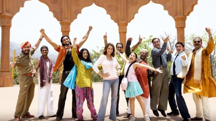 Aaja Nachle: A cheerful group of Indian people of various ages and styles pose outdoors, raising their arms and smiling energetically