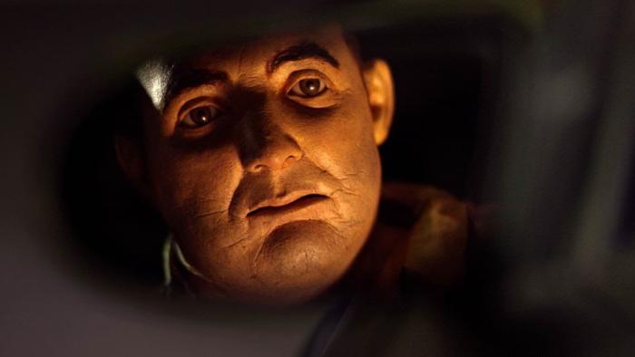 Abruptio Movie: Les Hackel (voiced by James Marsters) looks at his reflection in the rear-view mirror