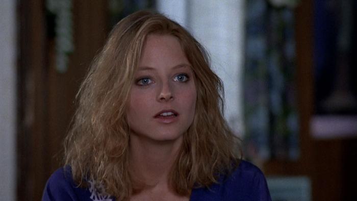 The Accused: Close-up of Jodie Foster's face, eyes wide, with a curtained window in the background.