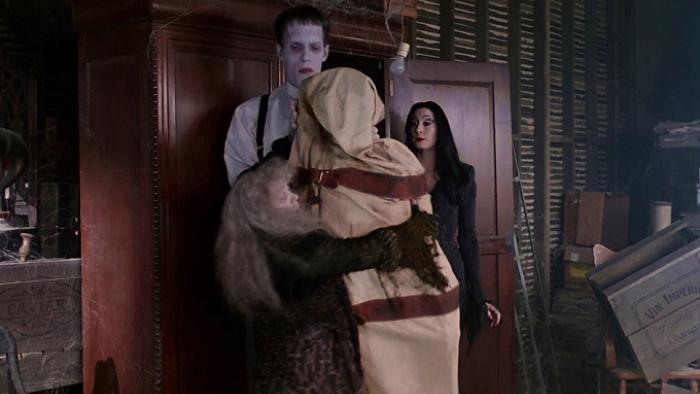 The Addams Family Movie: Two characters embrace while two others look on indoors