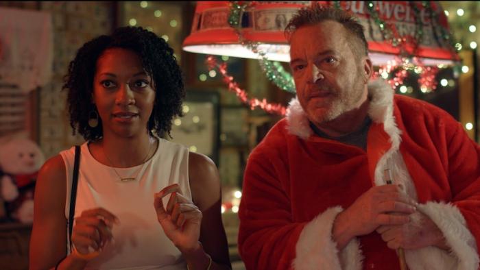 Adventures of the Naked Umbrella Movie: In a bar decorated for Christmas, parole officer Yolanda (Darnell Rhea) and Sheriff Buzz (Tom Arnold) seem to be talking about someone across the room