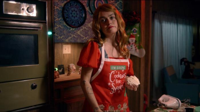 Adventures of the Naked Umbrella Movie: Irene Wanoutsky (Taryn Manning), wearing a festive Christmas apron, is in the kitchen, giving a disapproving look