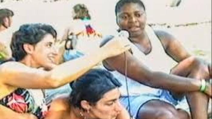 Ahead of the Curve: Women at beach talk on a microphone