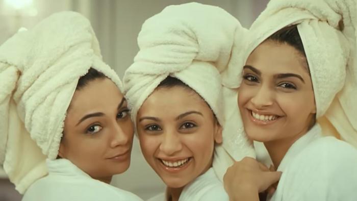 Aisha: Three young women smile posing together in their bathrobes with towels around their heads