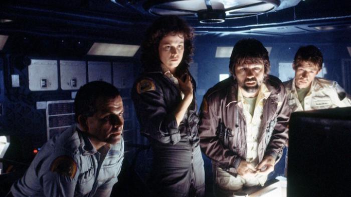 Alien Movie: Four White crew members look at a computer monitor inside a ship
