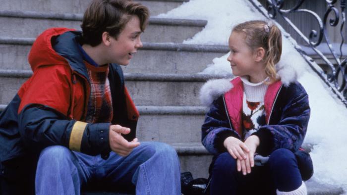 All I Want for Christmas movie: A young brother and sister smile as they talk on the steps of a New York house