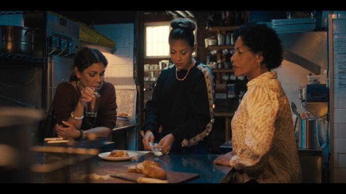 Allswell in New York movie: Daphne Rubin-Vega, Elizabeth Rodriguez, and Liza Colón-Zayas stand together at a table, looking concerned