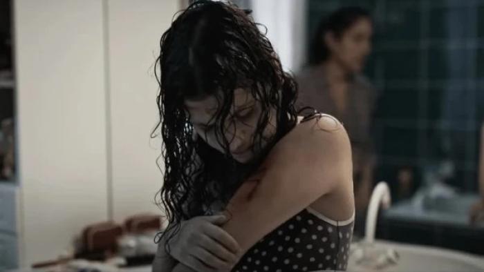 Alpha: A young teenage girl checks her arm tattoo