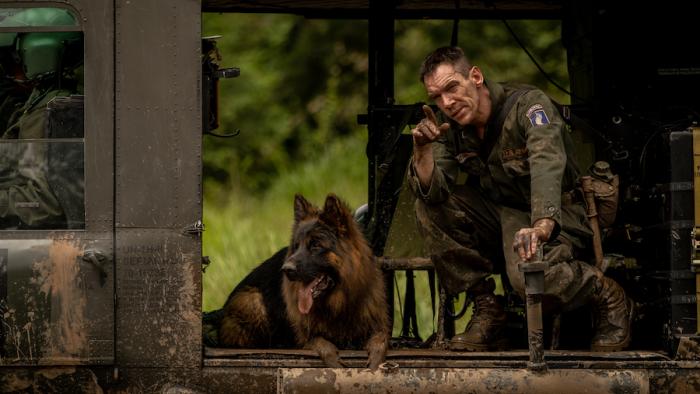 Ambush Movie: Miller (Jonathan Rhys Meyers) is on a chopper, his dog to the left of him, and points at something we can't see