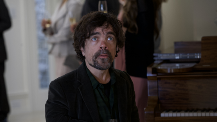 American Dreamer Movie: Peter Dinklage stands amid a group of people