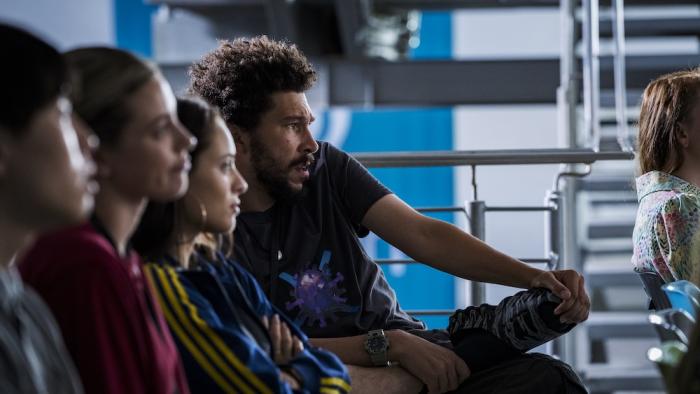 American Sweatshop Movie: Daisy, Ava, and Bob, along with other co-workers, listen to a company briefing
