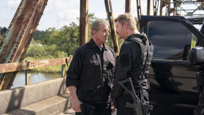 Armor Movie: On the bridge, near a black truck, Rook (Sylvester Stallone) and Smoke (Dash Mihok) have a tense discussion