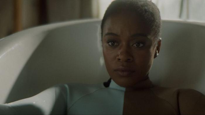 Assassin Movie: Alexa, wearing some kind of special brown and white suit, sits in a bathtub, ready for an experiment
