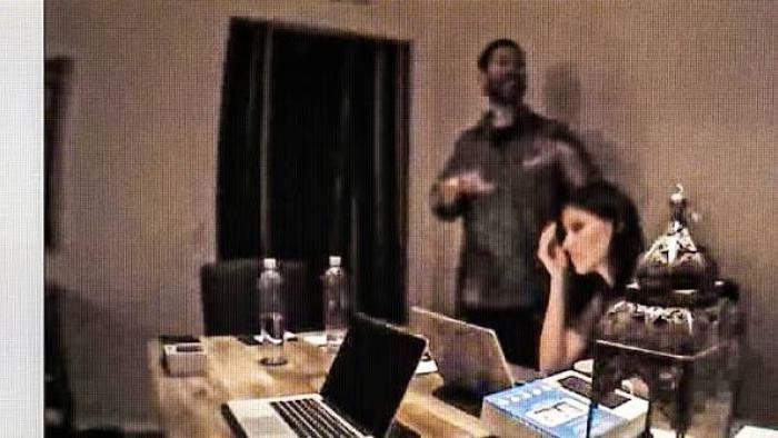 A Toxic Love Story:  Man standing and gesturing, woman seated at a table with laptops.