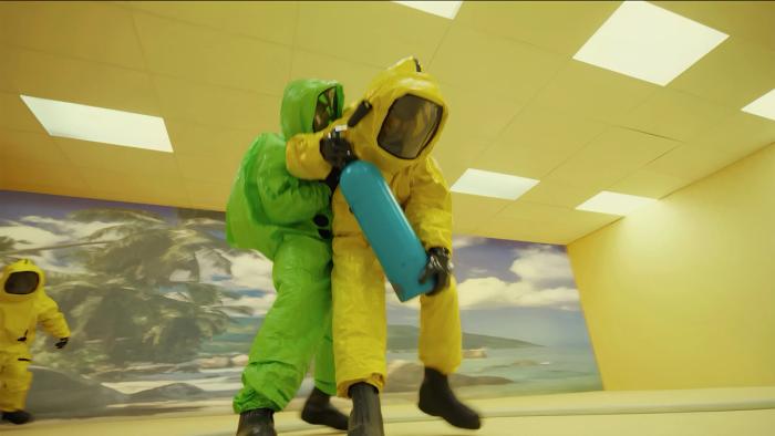 Backrooms Movie: Two figures wearing colorful suits hold fire extinguishers in the Backrooms