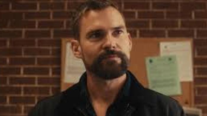 Bad Man Movie: Seann William Scott stands in front of bulletin board