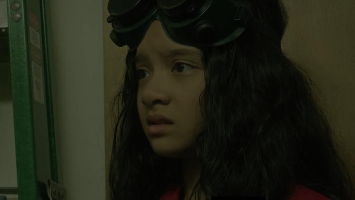 The Baker Movie: Delphi (Emma Ho), wearing goggles on her forehead, looks concerned