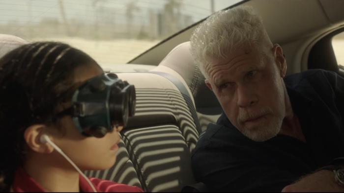 The Baker Movie: While sitting in a vehicle, Pappi (Ron Perlman, right), leans over to tell Delphi (Emma Ho) something