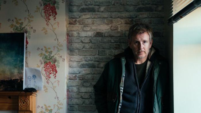 Ballywalter: Patrick Kielty stands against a wall by a living room window looking sad
