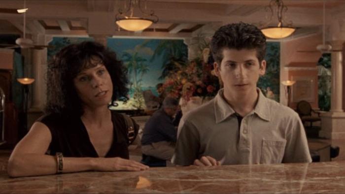 Bart Got a Room: Two people standing at a hotel desk, woman on the left, young man on the right, both attentive