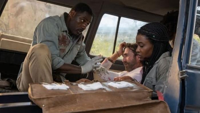 Beast Movie: A man and his young daughter give first-aid to a guy in the back of a car