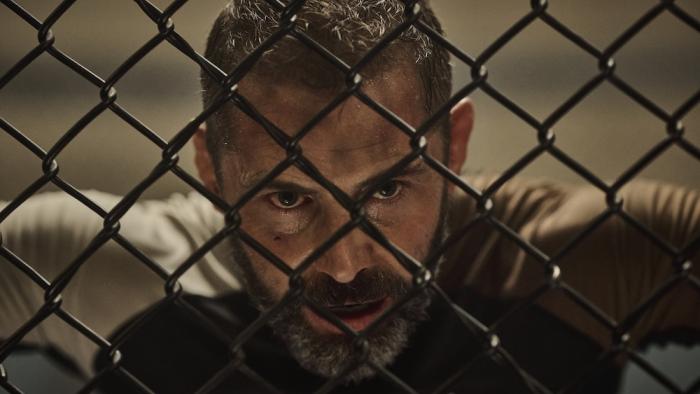 Beast Movie: During a rigorous training, an exhausted Patton James rests his head against a chain-link fence