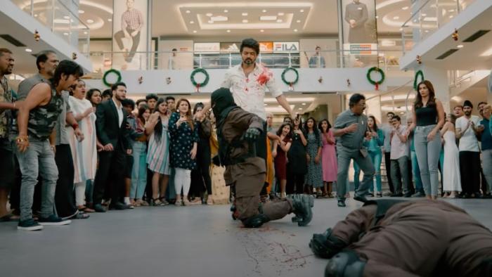 Beast: A middle-aged bearded Indian man with blood on his white shirt stands over two men he has just defeated in a fight while a crowd looks on