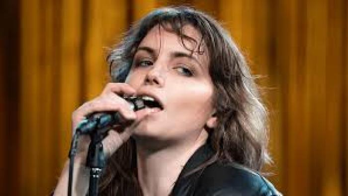 Beautiful Rebel movie: Italian white woman center holds microphone and sings into it