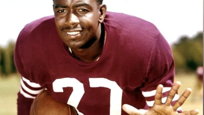 Because They Believed: Football legend R. C. Owens poses in uniform with one arm held in front of him and the other clutching a football