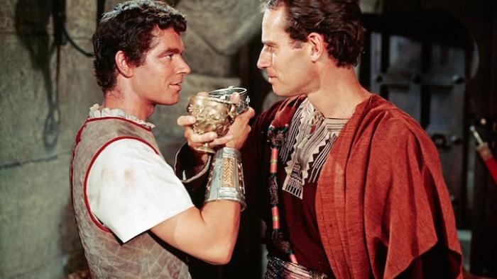 Ben Hur movie: Two men in Roman tunics face each other, sharing a goblet