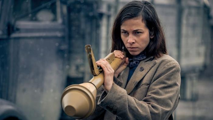 Blood & Gold: White German woman stands while holding bazooka center