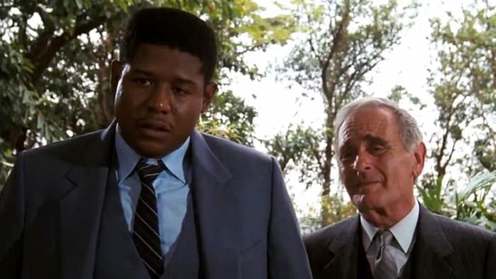 Bloodsport Movie: CID agents Rawlins (Forest Whitaker) and Helmer (Norman Burton) question someone in Hong Kong
