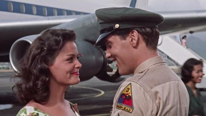 Blue Hawaii: Joan Blackman and Elvis Presley smile at each other in front of a plane