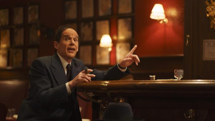Blue Moon Movie: Lorenz Hart (Ethan Hawke) sits at the bar and talks, gesturing with one hand, and a cigar in the other.