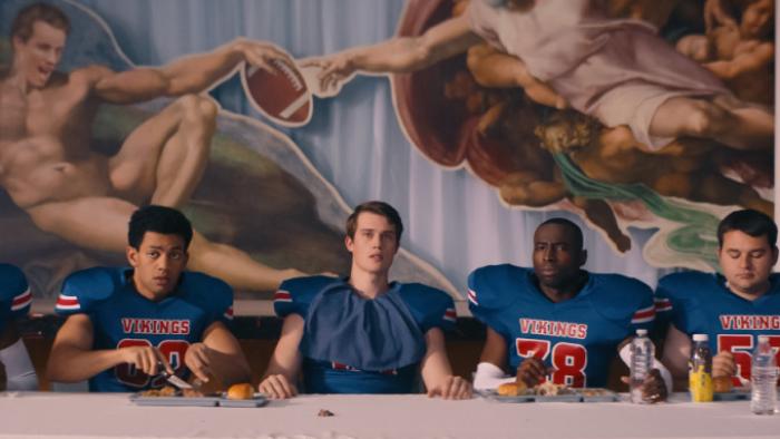 Bottoms Movie: Jeff sits at the center of a dinner table set in a Last Supper-type arrangement