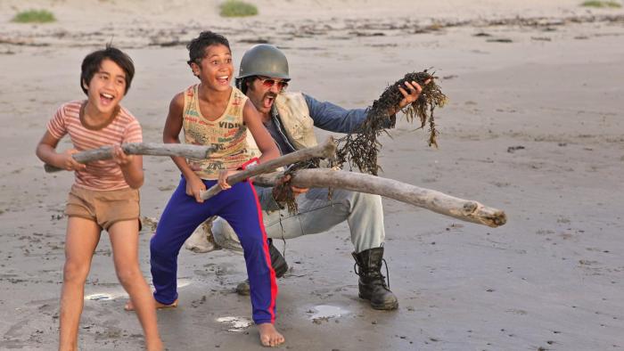 Boy Movie: A dad and two tweens play a battle game on a beach with driftwood and seaweed
