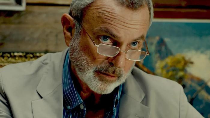 Bring Him to Me: Sam Neill wearing a gray blazer gives a stern look