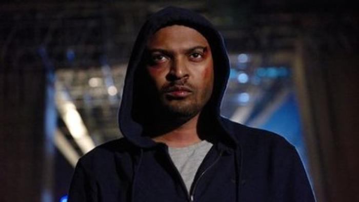 Brotherhood: A young Black Man walks through the dark city streets wearing a hoodie and with bruises on his face