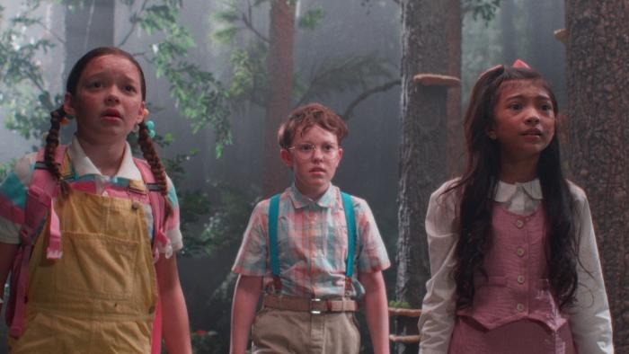 Buddy Movie: In the woods, three children dressed in pastel colors look frightened